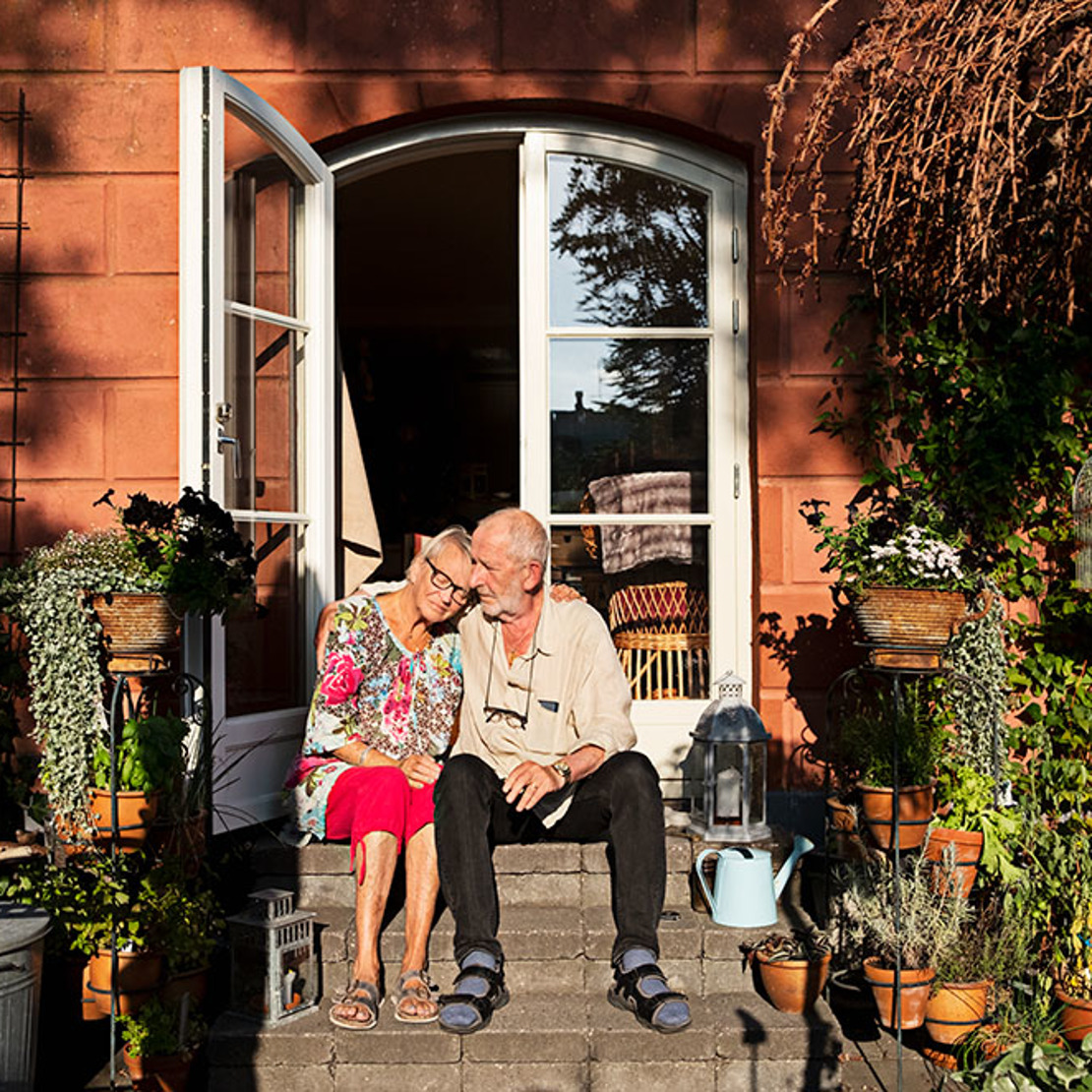 Äldre par som sitter på trappsteg i solen, foto 